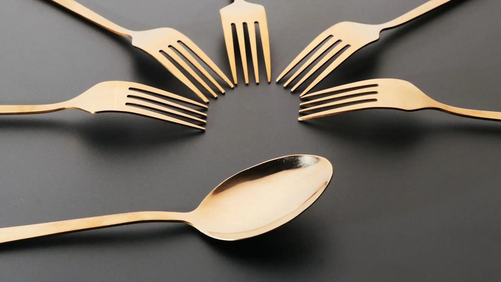 Bestick med olika finish på ett dukat bord